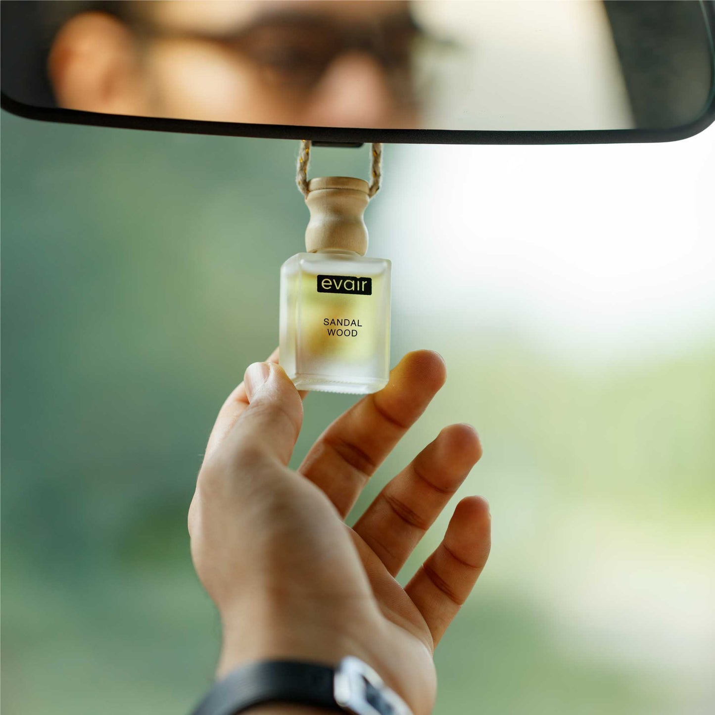 Man Holding Sandalwood Hanging Car Air Freshener in the Hand